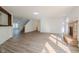 Spacious living room featuring wood-look flooring, fireplace, and view into the kitchen and stairway at 10309 Buckshire Ln, Indianapolis, IN 46234