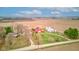 A captivating aerial view of a traditional farm with a vibrant red barn, silos, and a well-maintained house surrounded by green fields at 10573 W 550 N, Thorntown, IN 46071