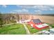 Aerial view of a stunning red barn with silos on a lush property with mature trees and a winding driveway at 10573 W 550 N, Thorntown, IN 46071