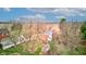 Aerial view of a brick home nestled amongst mature trees, with well-manicured grounds and outbuildings at 10573 W 550 N, Thorntown, IN 46071