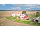 Aerial view of a countryside property featuring a rustic red barn, silos, and green surroundings at 10573 W 550 N, Thorntown, IN 46071