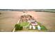 Serene aerial view of a rural landscape featuring a red barn, farmhouse, grain silos, and extensive farmland at 10573 W 550 N, Thorntown, IN 46071