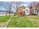View of a backyard featuring a well-maintained lawn, a deck, and mature trees surrounding the property at 10573 W 550 N, Thorntown, IN 46071
