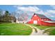 Scenic view of a red barn with white trim, set against a blue sky with puffy clouds, with ample green space at 10573 W 550 N, Thorntown, IN 46071