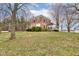 Exterior shot of a charming two-story brick home with manicured lawn and mature trees in a tranquil setting at 10573 W 550 N, Thorntown, IN 46071