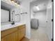 Bathroom with a wooden vanity, mirror, and a view into the laundry room at 13381 N White Cloud Ct, Camby, IN 46113