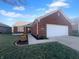 Charming red brick home with a two-car garage, well-kept lawn, and a welcoming entrance at 13381 N White Cloud Ct, Camby, IN 46113
