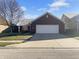 Charming home with red brick, 2-car garage, and a well-manicured lawn on a sunny day at 13381 N White Cloud Ct, Camby, IN 46113