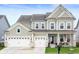 Charming two-story home featuring a three car garage, covered entry, and manicured lawn at 15046 Sullivan Ln, Westfield, IN 46074