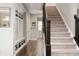 A hallway featuring a staircase, storage cubbies, hard wood floors, and neutral paint at 15046 Sullivan Ln, Westfield, IN 46074