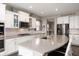 A modern kitchen boasts white cabinets, a gray countertop island with seating, and stainless steel appliances at 15046 Sullivan Ln, Westfield, IN 46074