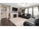 A cozy living room boasts a fireplace, a mounted TV, two black sofas, and hardwood floors at 15046 Sullivan Ln, Westfield, IN 46074