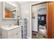 This bathroom features a single sink vanity, updated light fixture, and door leading to the living area at 1617 S N St, Elwood, IN 46036
