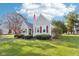 Picturesque home featuring a lush green lawn, mature trees, and patriotic American flag at 1617 S N St, Elwood, IN 46036