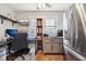 Bright home office featuring a desk, dual monitors, storage, and a stainless steel refrigerator at 1617 S N St, Elwood, IN 46036