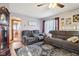 Open-concept living room with gray couches, ceiling fan, and view of the bathroom at 1617 S N St, Elwood, IN 46036