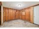 Room featuring a wood paneled walls, concrete floors, and an exit door at 1617 S N St, Elwood, IN 46036
