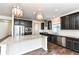 Open kitchen featuring granite countertops, stainless appliances, dark cabinets, and hardwood floors at 18203 Sunbrook Way, Westfield, IN 46074