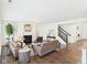 Open-concept living room with a fireplace, neutral decor, hardwood floors, and a staircase leading upstairs at 18203 Sunbrook Way, Westfield, IN 46074