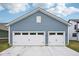 The two-car garage features a well-manicured lawn and a blue exterior for added curb appeal at 2156 W 171St St, Westfield, IN 46074