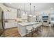 Open kitchen with an island, white cabinets, stainless steel appliances, and modern lighting at 2156 W 171St St, Westfield, IN 46074