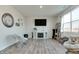 Bright living room with a fireplace, large clock, large windows, and modern decor at 2208 Gambel Ln, Danville, IN 46122