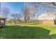 Large backyard with a well-maintained lawn, mature trees, and a view of the house at 2605 Rollins Ct, Indianapolis, IN 46268