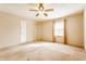 Bedroom with neutral walls and tan carpet features a ceiling fan and sunlit window at 2605 Rollins Ct, Indianapolis, IN 46268