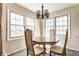 Cozy dining room featuring natural light from large windows and a chandelier above the wood table at 2605 Rollins Ct, Indianapolis, IN 46268