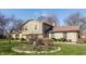 Attractive split-level home with stone and siding, complemented by landscaped flower beds in a verdant setting at 2605 Rollins Ct, Indianapolis, IN 46268