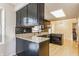 Modern kitchen with sleek black cabinets, granite countertops, and stainless steel appliances, with hardwood floors at 2605 Rollins Ct, Indianapolis, IN 46268