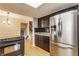 Kitchen features stainless steel fridge, black cabinets, black tiled backsplash, and wooden floors at 2605 Rollins Ct, Indianapolis, IN 46268