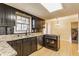 Well-lit kitchen features black cabinets, granite countertops, and stainless steel appliances at 2605 Rollins Ct, Indianapolis, IN 46268