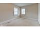 A bright, carpeted bedroom featuring neutral-toned walls and two windows offering plenty of natural light at 2620 Central Ave, Indianapolis, IN 46205
