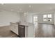 Open kitchen features white cabinets, center island with sink, hardwood floors, and stainless appliances at 268 Onset Way, Westfield, IN 46074