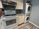Efficient kitchen features white appliances, an above-range vent, and modern stacked washer and dryer at 2765 Del Prado Dr # 7, Indianapolis, IN 46227