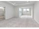 Spacious main bedroom featuring plush carpet, tray ceiling, and a view of the outdoors at 3308 Morab Dr, Zionsville, IN 46077