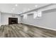 Finished basement with gray wood floors, recessed lighting, brick fireplace, and windows at 3701 Dorval Pl, Indianapolis, IN 46228