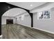 Finished basement with gray wood floors, recessed lighting, brick fireplace, and windows at 3701 Dorval Pl, Indianapolis, IN 46228