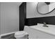 Bathroom featuring a sleek vanity with a gray and black accent wall and a modern round mirror at 3701 Dorval Pl, Indianapolis, IN 46228
