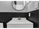 Bathroom featuring a sleek vanity with a gray and black accent wall and a modern round mirror at 3701 Dorval Pl, Indianapolis, IN 46228