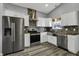 Updated kitchen features stainless steel appliances, white cabinets, and modern backsplash at 3701 Dorval Pl, Indianapolis, IN 46228