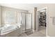 Bright bathroom featuring a soaking tub, a glass shower and a walk-in closet filled with clothes at 3998 Jonathan Rdg, Columbus, IN 47201