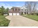 Stunning view of a brick two-story home with a three-car garage and a long driveway at 3998 Jonathan Rdg, Columbus, IN 47201