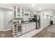 Basement kitchenette area with white cabinets, wine cooler, stainless steel refrigerator, and gray countertops at 3998 Jonathan Rdg, Columbus, IN 47201