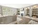 Living room with gray couch, fireplace, mounted TV, and built-in shelving overlooking the fenced backyard at 3998 Jonathan Rdg, Columbus, IN 47201