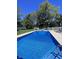 Sparkling in-ground pool surrounded by lush greenery and a charming white picket fence, perfect for summer relaxation at 3998 Jonathan Rdg, Columbus, IN 47201