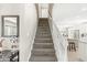 Carpeted stairway with white railing leading up, adjacent to a kitchen and dining area at 3998 Jonathan Rdg, Columbus, IN 47201