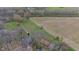 Aerial view of a house, a field, and a wooded area in a serene natural setting at 4935 W Carriage Dr, New Palestine, IN 46163