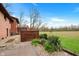 Spacious backyard features a deck, greenery, and landscape with a brick house at 4935 W Carriage Dr, New Palestine, IN 46163